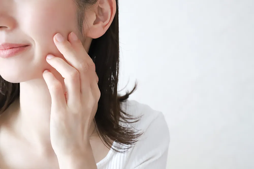 口元に手を当てる女性